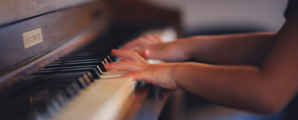 person playing upright piano